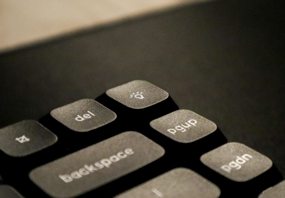 Hands typing on a laptop keyboard with documents